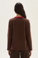 Remera de algodón de corte recto, con cuello a la base y mangas largas. Presenta costuras con pespuntes a contratono y un pequeño bordado en el pecho.