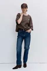 Remera de algodón color marrón chocolate, con corte oversize, cuello redondo y pequeño bordado de trébol en el pecho.