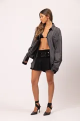 Camisa de manga larga con corte relajado, confeccionada en microfibra con estampado abstracto de líneas verticales en tonos grises. Presenta cuello clásico, cierre frontal con botones, bolsillo en el pecho con el nombre de la marca bordado.