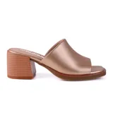 Sandalia tipo mule color dorado, con punta cuadrada y taco bloque bajo.