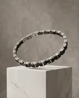 Pulsera de eslabones fabricada en acero inoxidable con incrustaciones de cerámica negra.