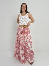 Falda larga de algodón con estampado floral en tonos rosados y blancos. Tiene cintura elastizada y cinto de rafia desmontable.