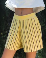 Short amarillo con rayas verticales negras, tejido con lurex y cintura elástica.