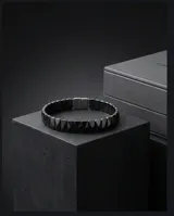Pulsera de eslabones rectangulares con acabado facetado en color negro, fabricada en una combinación de acero y cerámica.