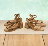 Sandalias de cuero color dorado, con plataforma y taco cuadrado. Presentan tiras cruzadas en el empeine y pulsera al tobillo con hebilla.