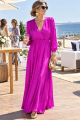 Vestido largo de satén de seda natural color fucsia, con escote cruzado en V, manga larga abullonada, cintura elastizada y falda larga con caída fluida.