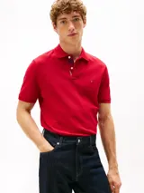 Chomba de corte regular Tommy Hilfiger, color rojo, confeccionada en algodón orgánico con un toque de elastano. Presenta cuello tipo chomba, cartera de dos botones, tejido piqué y logo de la marca bordado en el pecho.