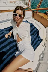 Chaqueta de punto blanco con diseño pointelle, cuello redondo, manga larga y cierre frontal con botones.