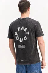 Remera de algodón color marrón con efecto gastado, de manga corta, cuello redondo y estampa tipográfica sutil al frente.