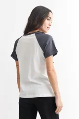 Remera blanca con mangas raglán grises y estampado frontal de Mickey Mouse con texto.