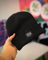 Gorro de invierno negro de punto con etiqueta cosida con el logo de la marca.