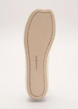Zapato chatita de cuero ovino color beige, de diseño minimalista con punta redonda y suela de cuero.