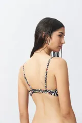 Top de bikini con estampado floral multicolor, corte triangular y breteles finos regulables.