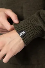 Sweater de punto grueso en color verde oliva, con diseño oversized, cuello redondo y mangas largas con puños acanalados.