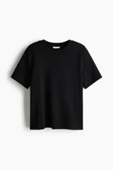Remera de punto interlock pesado color negro, con cuello redondo ribeteado en canalé, mangas cortas y bajo recto.