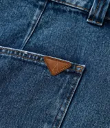 Short de jean azul de tiro alto, con pliegues delanteros y ruedo largo.