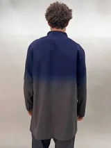 Camisa de lana color gris con cuello mao, corte recto y mangas largas con detalle texturizado. Presenta cierre invisible en el escote superior y tajos laterales.