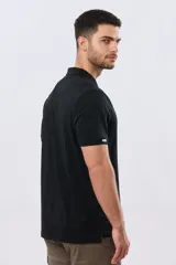 Remera polo de manga corta en color azul melange, con cuello camisero, cierre frontal de dos botones y pequeño bordado en el pecho.