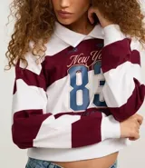 Blusa de malla de algodón con cuello de solapa y mangas largas. Tiene patrón de rayas bold y estampa delantera con lettering sportcore.