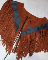 Pechera de cuero color marrón con flecos y apliques de cuero negro. Se ata al cuello con cordones.