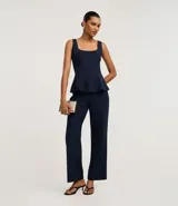 Pantalón de vestir azul marino, de corte recto y cintura alta, con frisos verticales y bolsillos falsos delanteros.