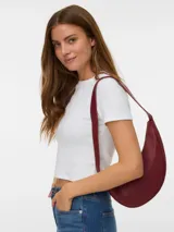 Cartera de hombro tipo hobo en color bordó, con diseño curvo y estructura rígida. Cuenta con cierre superior y correa fija al hombro.