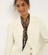 Pañuelo cuadrado de satén con estampado animal print de leopardo. Incluye una argolla metálica para facilitar su anudado y estilizado.