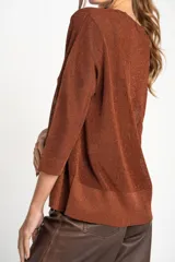 Sweater de punto con acabado brillante, cuello en V y mangas tres cuartos. Presenta un diseño holgado y tejido traslúcido.