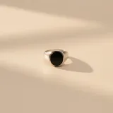 Anillo tipo sello de plata 925 con piedra central circular de resina negra.