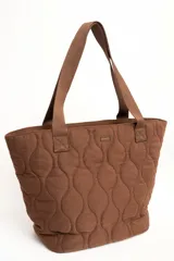 Bolso tipo tote bag de color marrón, con diseño acolchado capitoneado en patrón ondulado. Cuenta con doble asa de hombro y placa metálica frontal con el grabado de la marca Lemon.