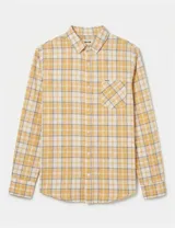 Camisa de manga larga con estampado de cuadros en tonos amarillos, blancos y grises. Presenta cuello clásico, cierre frontal con botones, puños abotonados y un bolsillo en el pecho con etiqueta de la marca.