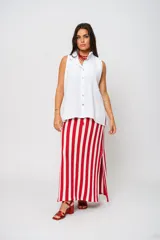 Camisa blanca sin mangas con cuello mao adornado con un delicado volado y cierre frontal con botones.