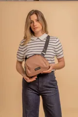 Bandolera pequeña de diseño moderno, confeccionada en tafeta liviana y resistente. Cuenta con cierre superior, correa ancha ajustable y logo frontal de la marca.