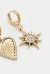 Aro colgante dorado con dije en forma de sol adornado con pedrería.