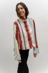 Chaqueta liviana de jean celeste con cuello mao, cierre frontal con alamares y detalle de bordados florales.