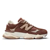 Championes urbanos New Balance modelo 9060, en tonos marrón y beige, confeccionados con capellada de malla y superposiciones de gamuza, con entresuela gruesa esculpida y el característico logotipo "N" en los laterales.