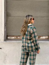 Blazer de corte recto con estampado de cuadros en tonos verdes, beige y negro, con cierre frontal de botones y bolsillos laterales.