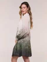 Vestido corto de gasa estampada con motivos botánicos en tonos verdes y crudo, diseñado por Julia Jordan. Cuenta con cuello alto con lazo para atar, abertura frontal con botones, delantera plisada, mangas largas abullonadas y un lazo ajustable en la cintura. Incluye forro interno.