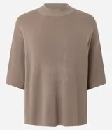 Blusa de manga corta amplia y sisas desplazadas, confeccionada en punto leve de viscosa y poliamida, con cuello redondo ligeramente alto.