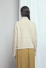 Cardigan de punto color gris oscuro melange, con cuello alto, mangas largas y cierre frontal con botones marrones.