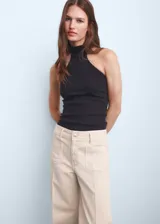 Pantalón tipo jeans de tiro alto y corte wide leg, color beige. Presenta cierre frontal con cremallera y botón, trabillas para cinturón y dos bolsillos de parche en la parte delantera.