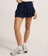 Short pollera de viscosa color azul marino, con cintura elástica y lazo ajustable, con diseño de volados superpuestos.