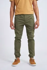 Pantalón cargo color beige con ajuste slim, cierre frontal con botón, bolsillos laterales tipo cargo y puños elásticos en los tobillos.