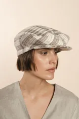 Boina con visera de lana fina uruguaya natural, sin teñir, con diseño de tejido texturizado en tonos beige y marrón.