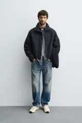 Cazadora de corte cropped confeccionada en tejido de algodón con ligero acolchado interior. Presenta cuello subido, cierre frontal con cremallera, mangas largas con puños elásticos y bolsillos laterales de vivo.