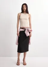 Top de punto fino y diseño entallado, color beige, con cuello redondo y tirantes anchos sin mangas.