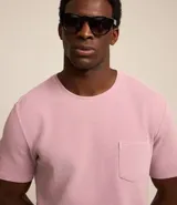 Remera de hombre, modelo comfort, color rosado claro con efecto lavado, confeccionada en algodón texturizado, con cuello redondo, mangas cortas y bolsillo delantero.