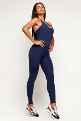 Monopieza deportiva color azul marino, de corte largo, con cuello halter y espalda descubierta.
