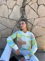 Sweater de punto con cuello redondo y estampado abstracto en tonos pastel: verde, celeste, marrón y blanco.