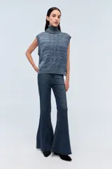 Chaleco de punto azul con cuello alto y diseño de trenzas.